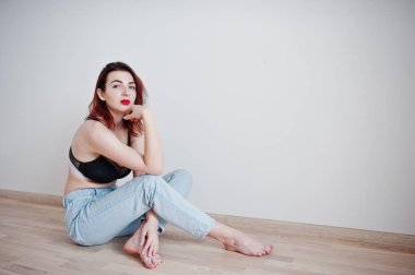 Siyah sütyen ve kot w karşı büyük bir büstü ile kırmızı saçlı kız