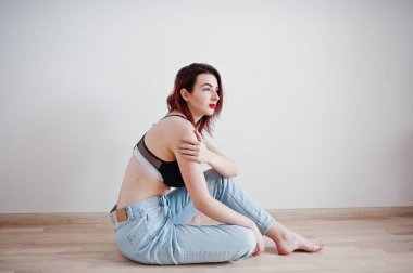 Siyah sütyen ve kot w karşı büyük bir büstü ile kırmızı saçlı kız