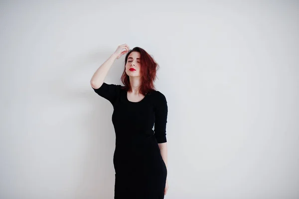 Rudowłosy dziewczyna na czarna sukienka tunika ścianę biały o pusty — Zdjęcie stockowe