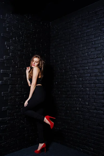 Csinos barna lány viselni a fekete és a piros magas sarkú, pózol — Stock Fotó