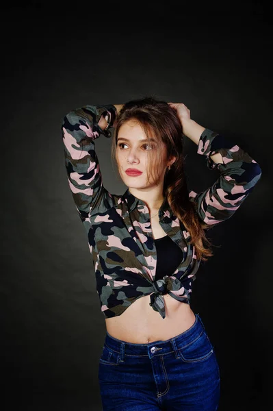 Menina morena bonito usar camisa militar e jeans, posando em — Fotografia de Stock