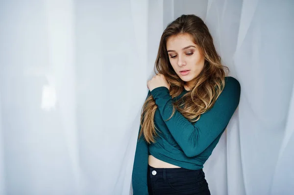 Przystojny brunette dziewczyna nosić na zielono, pozowanie na zasłony. Studio — Zdjęcie stockowe
