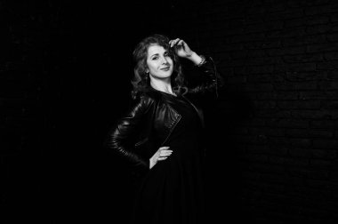 Kıvırcık saçlı kız studio siyah tuğla karşı deri ceket 