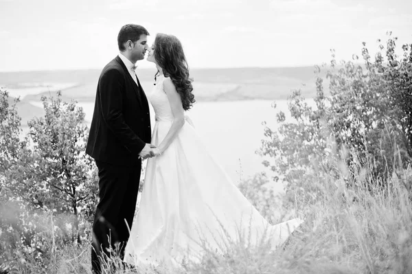 ロックと湖の息をのむ風景で結婚式のカップル. — ストック写真