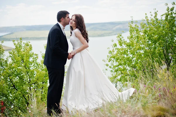 Casamento casal na paisagem de tirar o fôlego com rocha e lago . — Fotografia de Stock