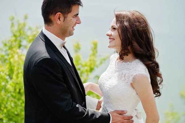 Pareja de bodas en un paisaje impresionante con roca y lago . — Foto de Stock