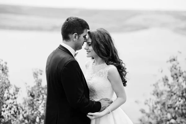 Cuplu de nunta la peisaj uluitor cu piatra si lac . — Fotografie, imagine de stoc