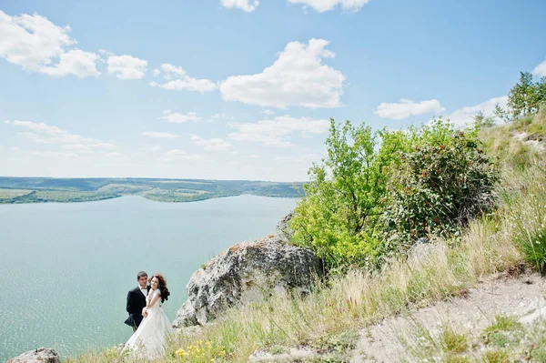 Couple de mariage à couper le souffle paysage avec rocher et lac . — Photo