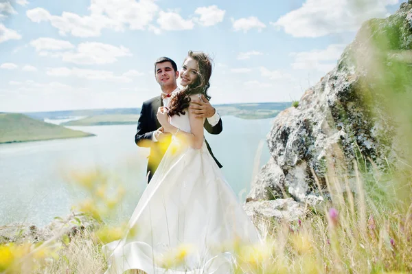 Couple de mariage à couper le souffle paysage avec rocher et lac . — Photo