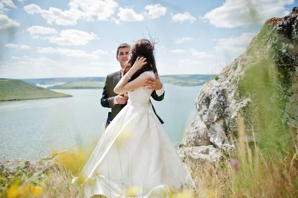 Pareja de bodas en un paisaje impresionante con roca y lago . —  Fotos de Stock