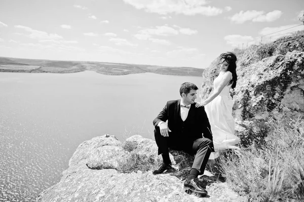 Γαμήλιο ζεύγος στο μαγευτικό τοπίο με ροκ και λίμνη. — Φωτογραφία Αρχείου