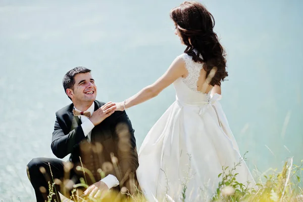 Casamento casal na paisagem de tirar o fôlego com rocha e lago . — Fotografia de Stock