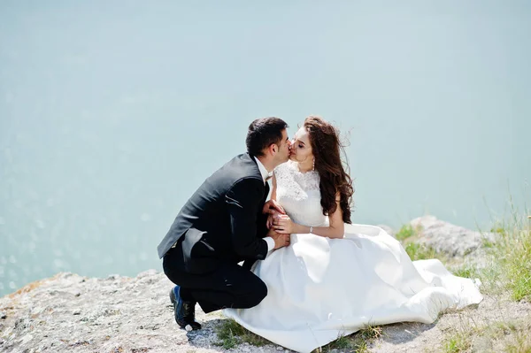 Para ślub w zapierające dech w piersiach krajobraz z rock i jeziora. — Zdjęcie stockowe