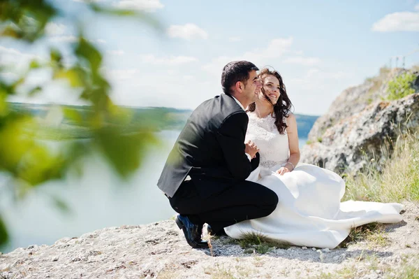 Svatební pár na úchvatnou krajinu s rockem a jezero. — Stock fotografie