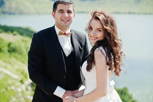Весільна пара на захоплюючому ландшафті з камінням і озером . — стокове фото