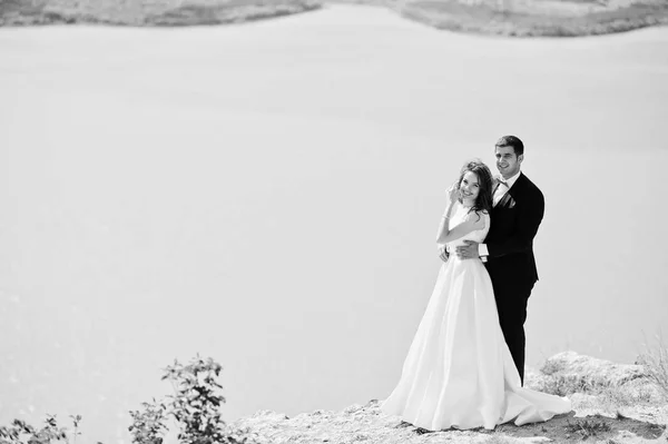 Casamento casal na paisagem de tirar o fôlego com rocha e lago . — Fotografia de Stock