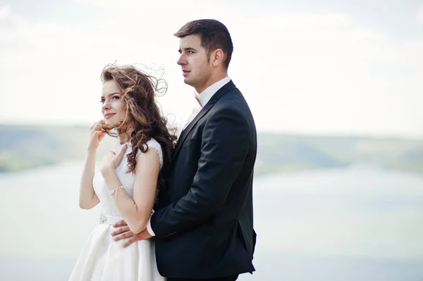 Pareja de bodas en un paisaje impresionante con roca y lago . —  Fotos de Stock