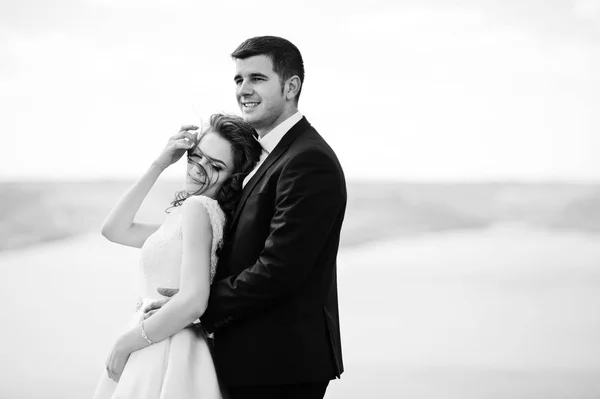 Hochzeitspaar in atemberaubender Landschaft mit Fels und See. — Stockfoto