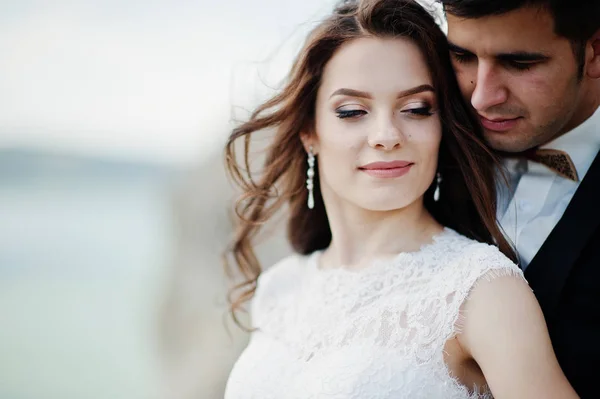 Pareja de bodas en un paisaje impresionante con roca y lago . — Foto de Stock