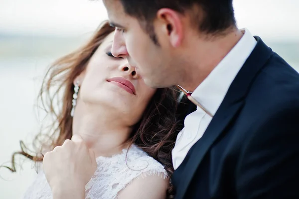 Casamento casal na paisagem de tirar o fôlego com rocha e lago . — Fotografia de Stock