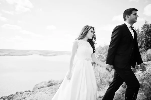 Casamento casal na paisagem de tirar o fôlego com rocha e lago . — Fotografia de Stock