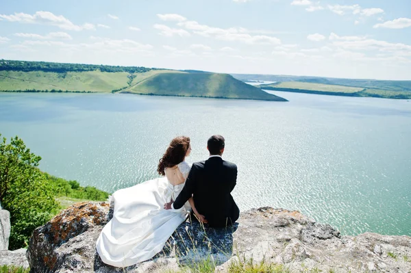 Pareja de bodas en un paisaje impresionante con roca y lago . — Foto de Stock