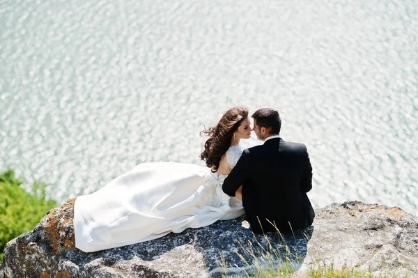 Pareja de bodas en un paisaje impresionante con roca y lago . —  Fotos de Stock