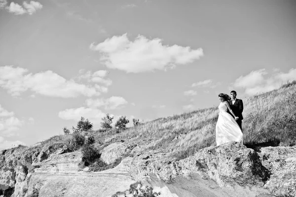 Wedding couple at breathtaking landscape with rock and lake. — Stock Photo, Image
