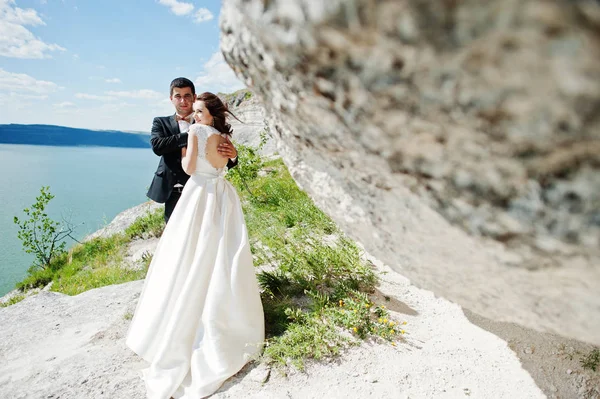 Bruidspaar op adembenemende landschap met rock en meer. — Stockfoto