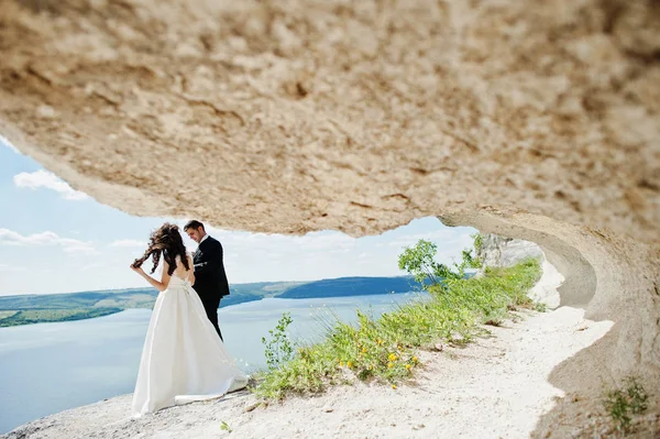 Casamento casal na paisagem de tirar o fôlego com rocha e lago . — Fotografia de Stock