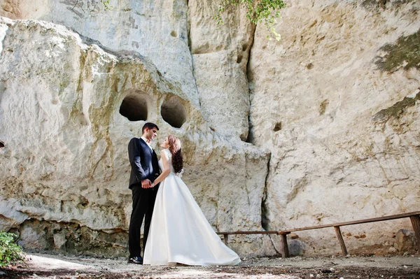 Hochzeitspaar gegen Höhle am Sommertag. — Stockfoto