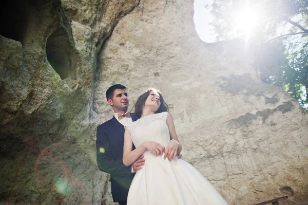 Wedding couple against cave at summer day. — Stock Photo, Image