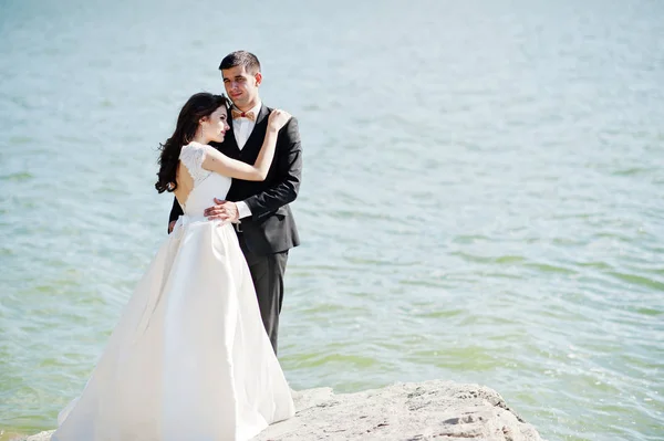 Esküvői pár a lélegzetelállító tájat a rock és a tó. — Stock Fotó