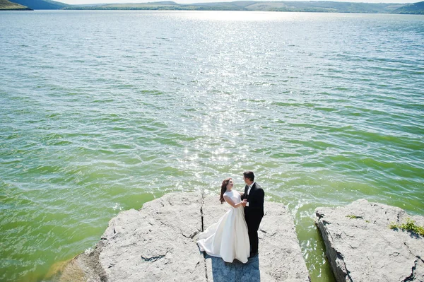 Весільна пара на захоплюючому ландшафті з камінням і озером . — стокове фото