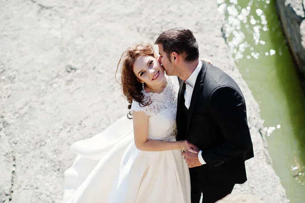 Svatební pár na úchvatnou krajinu s rockem a jezero. — Stock fotografie