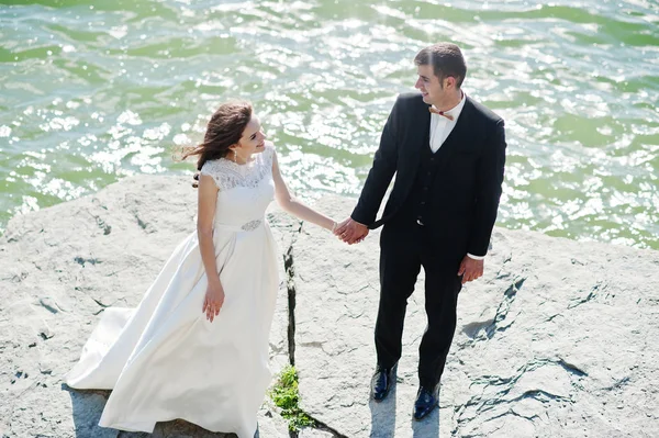 Casamento casal na paisagem de tirar o fôlego com rocha e lago . — Fotografia de Stock