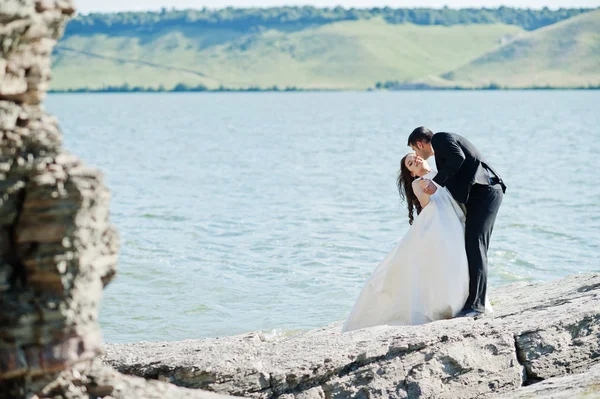 ロックと湖の息をのむ風景で結婚式のカップル. — ストック写真