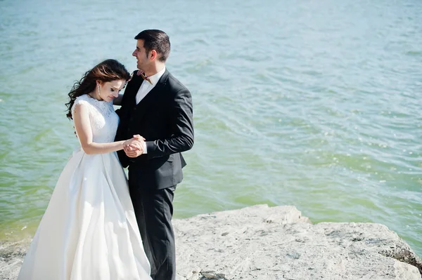 Casamento casal na paisagem de tirar o fôlego com rocha e lago . — Fotografia de Stock