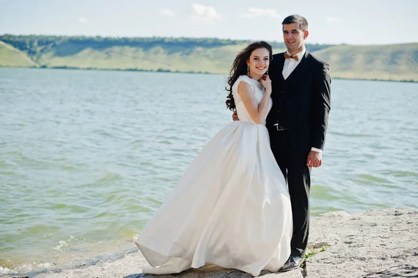 Casamento casal na paisagem de tirar o fôlego com rocha e lago . — Fotografia de Stock