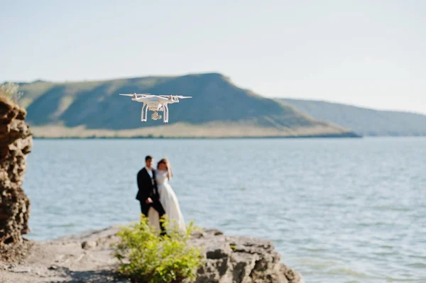 Couple de mariage à couper le souffle paysage avec rocher et lac . — Photo