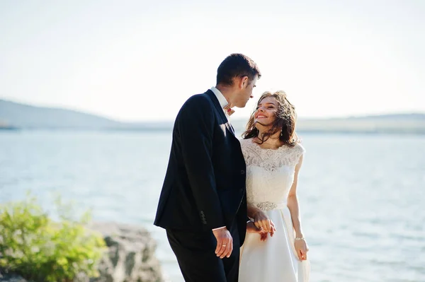 Couple de mariage à couper le souffle paysage avec rocher et lac . — Photo