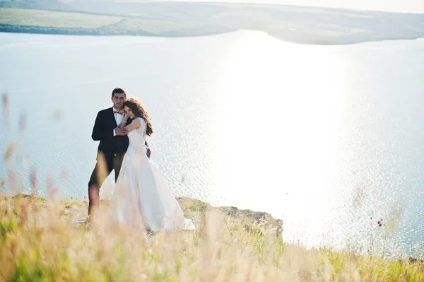 Matrimonio coppia a paesaggio mozzafiato con roccia e lago . — Foto Stock