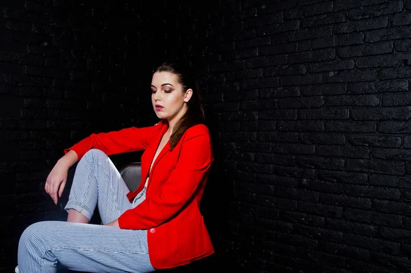 Elegante chica morena en chaqueta roja contra el estudio de ladrillo negro w — Foto de Stock