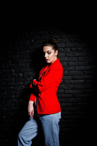 Elegante chica morena en chaqueta roja contra el estudio de ladrillo negro w —  Fotos de Stock