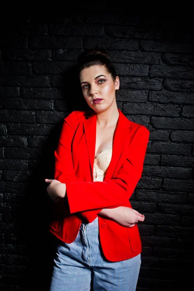 スタジオ黒レンガ w に対して赤いジャケットにスタイリッシュなブルネットの少女 — ストック写真
