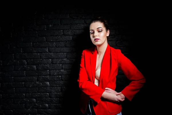 Élégante fille brune sur veste rouge contre studio brique noire w — Photo