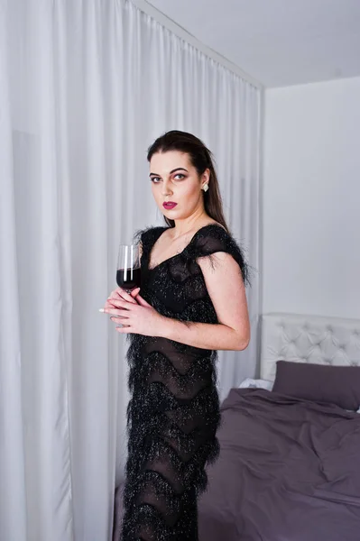 Barna lány Fekete estélyi ruhában gazdaság pohár bor újra — Stock Fotó