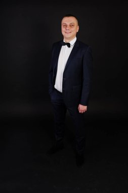 Şık erkek takım elbise siyah izole studio üzerinde poz verdi.