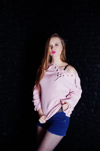 Studio skott av brunett tjej på rosa tröja med jeansshorts en — Stockfoto