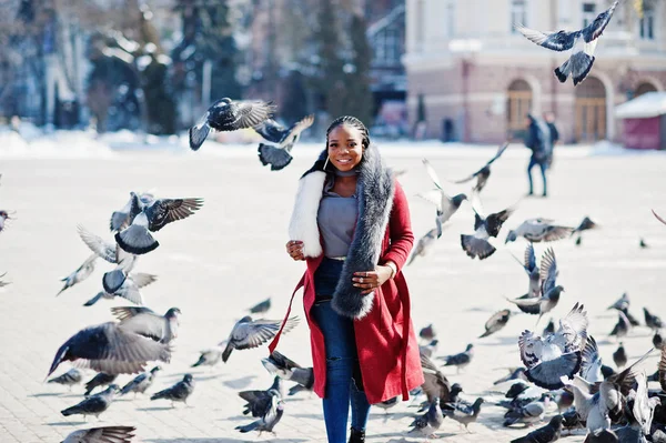 Rica africana americana chica en rojo abrigo y piel contra multitud de — Foto de Stock